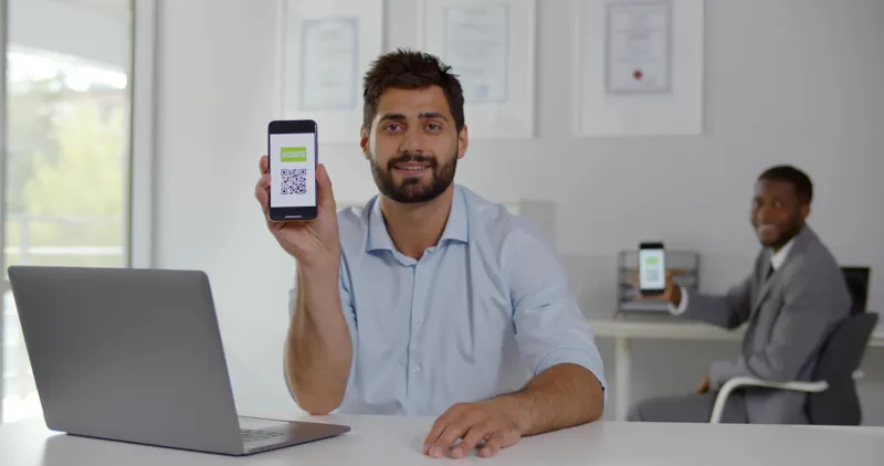 Director de un centro de capacitación mostrando en su celular el código QR de un certificado listo para verificarlo