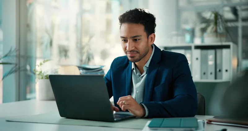 Gerente comparando en su laptop el precio del correo corporativo de Gmail, Microsoft 365 y un plan económico
