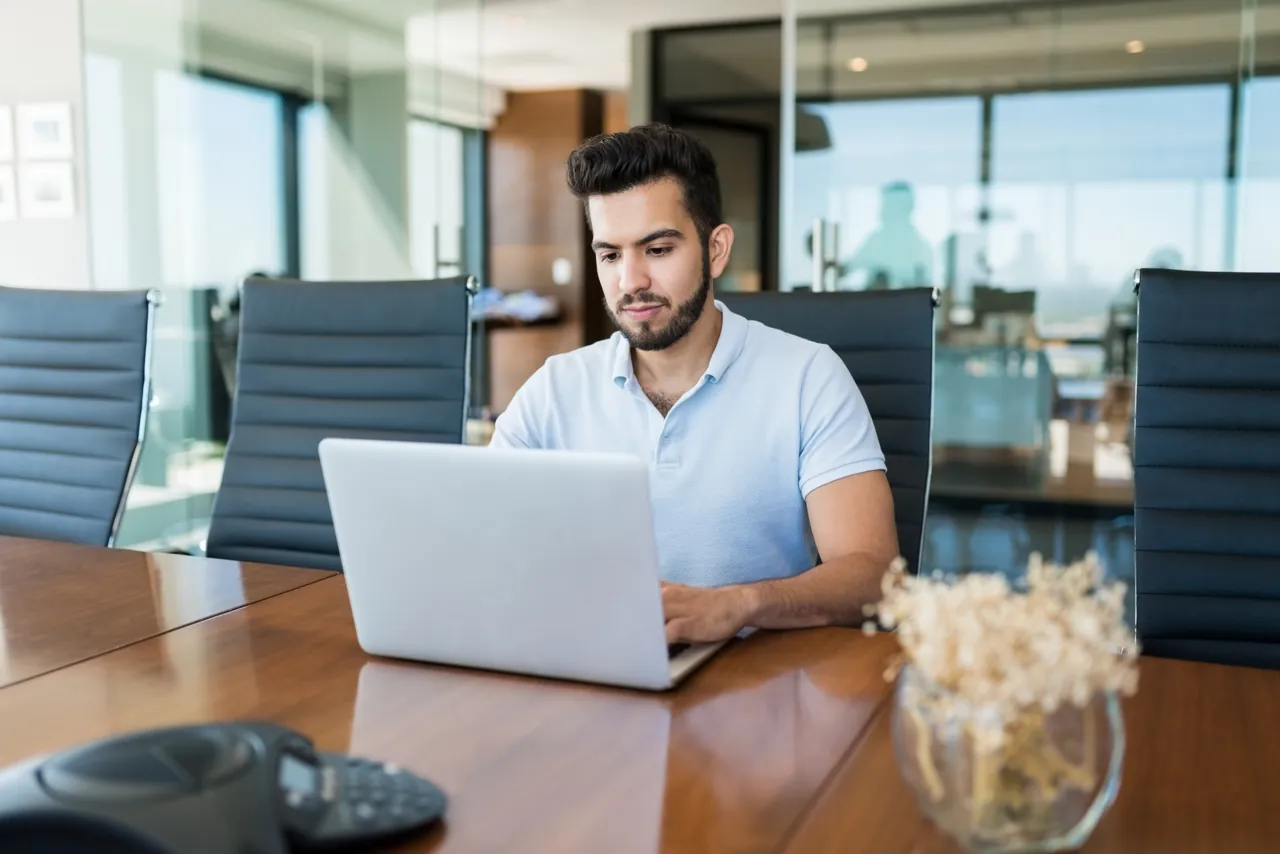 Gerente revisando en su laptop los planes de correo corporativo antes de decidir