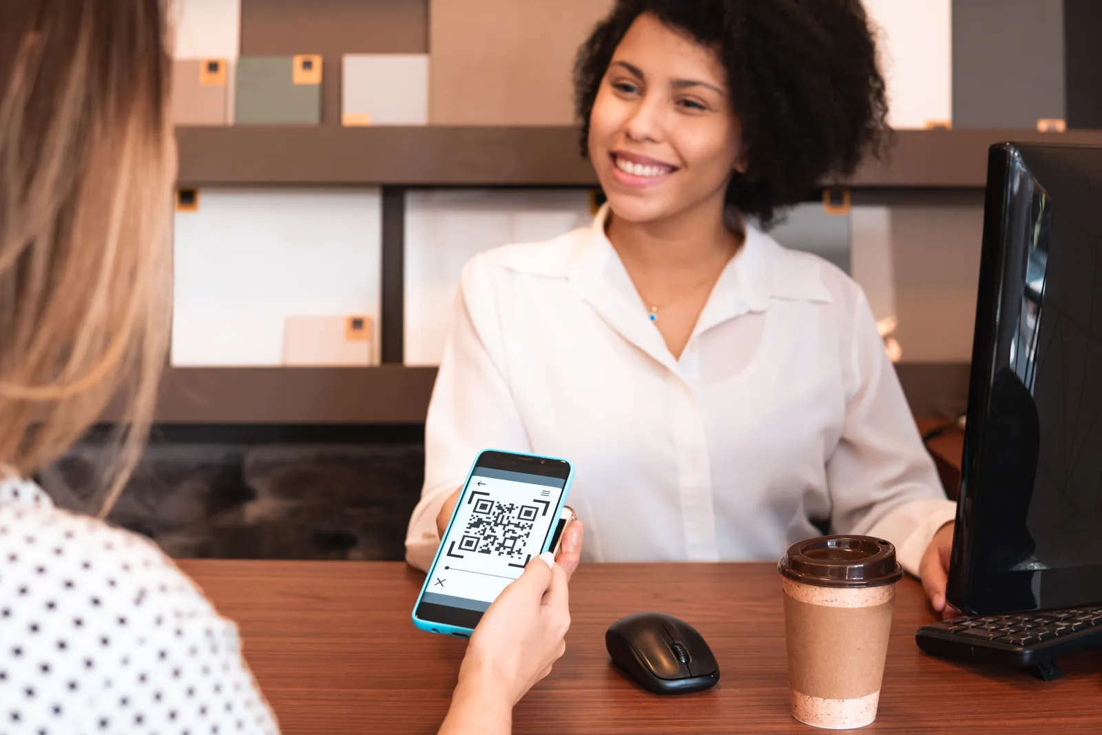 Cliente pagando con el código QR de su celular en el mostrador de un negocio, como se paga con Yape