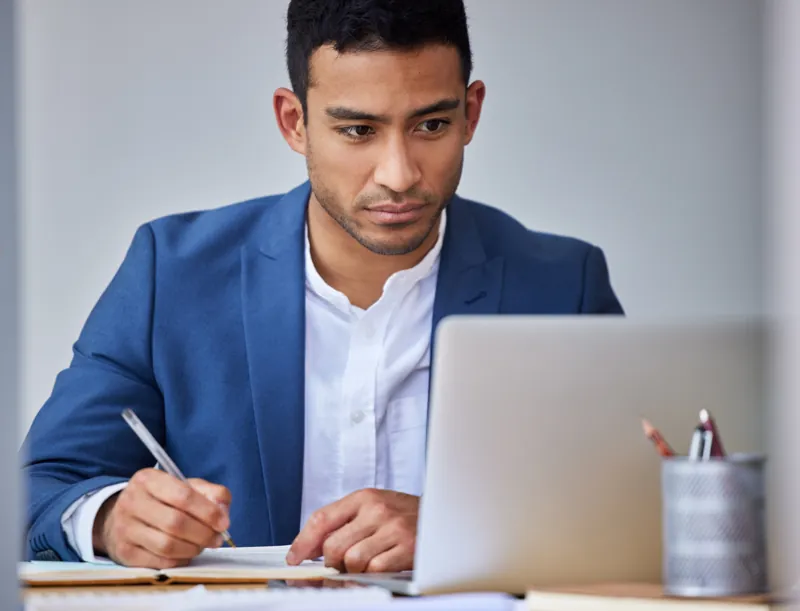 Coordinador académico revisando en su laptop la checklist para lanzar un curso online antes de abrir la matrícula