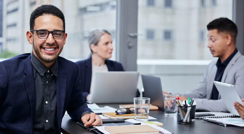 Director de una academia sonriendo en una reunión de trabajo donde su equipo evalúa lanzar una membresía para cursos online
