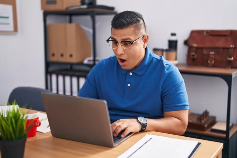 Dueño de un negocio sorprendido frente a su laptop al ver que su web no abre porque el dominio está vencido